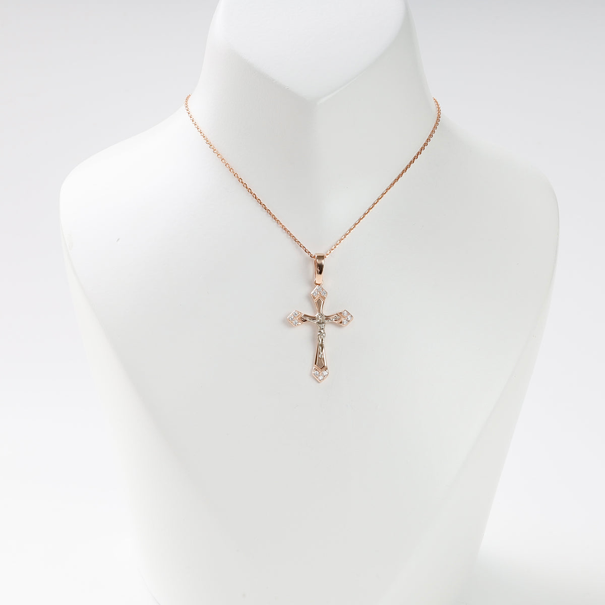 14K (585) rose gold crucifix pendant, shown on an illustrative chain on a white mannequin.