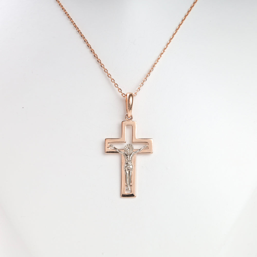 Rose gold crucifix pendant necklace with Jesus motif on a fine chain, displayed against a white background.