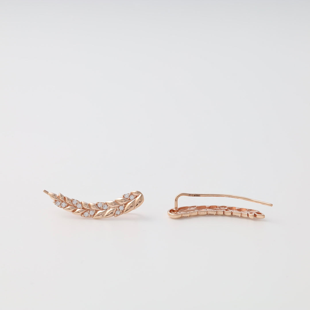 Rose gold leaf climber earrings with small clear crystals, displayed as a pair on a white background.