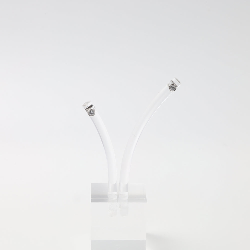 Pair of sterling silver diamond stud earrings on clear stand, minimalist Ukrainian Jewelry for modern silver stud earring shoppers.