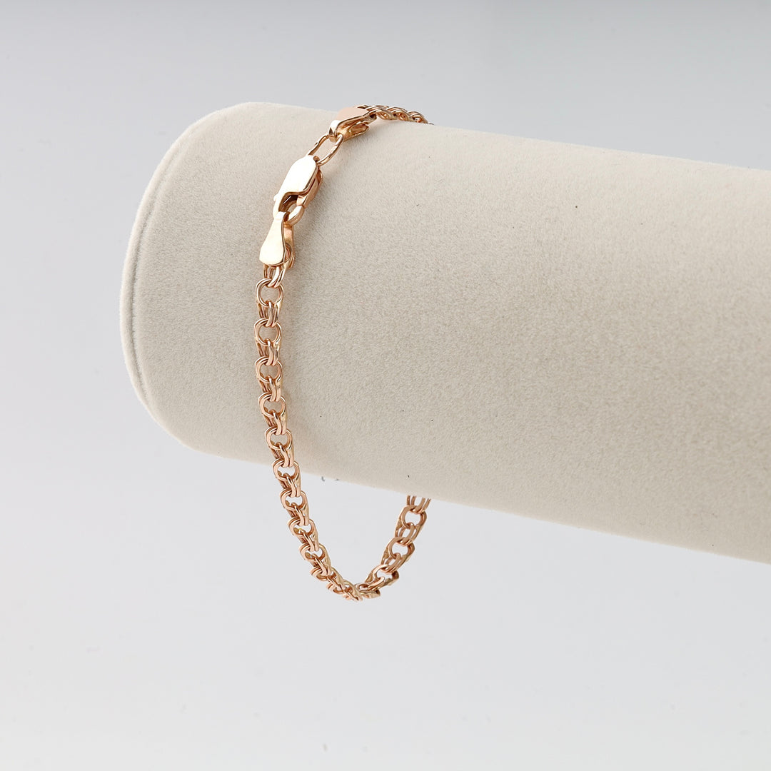 Rose gold chain bracelet with round links, displayed on a cream velvet jewelry stand, classic chain bracelet.