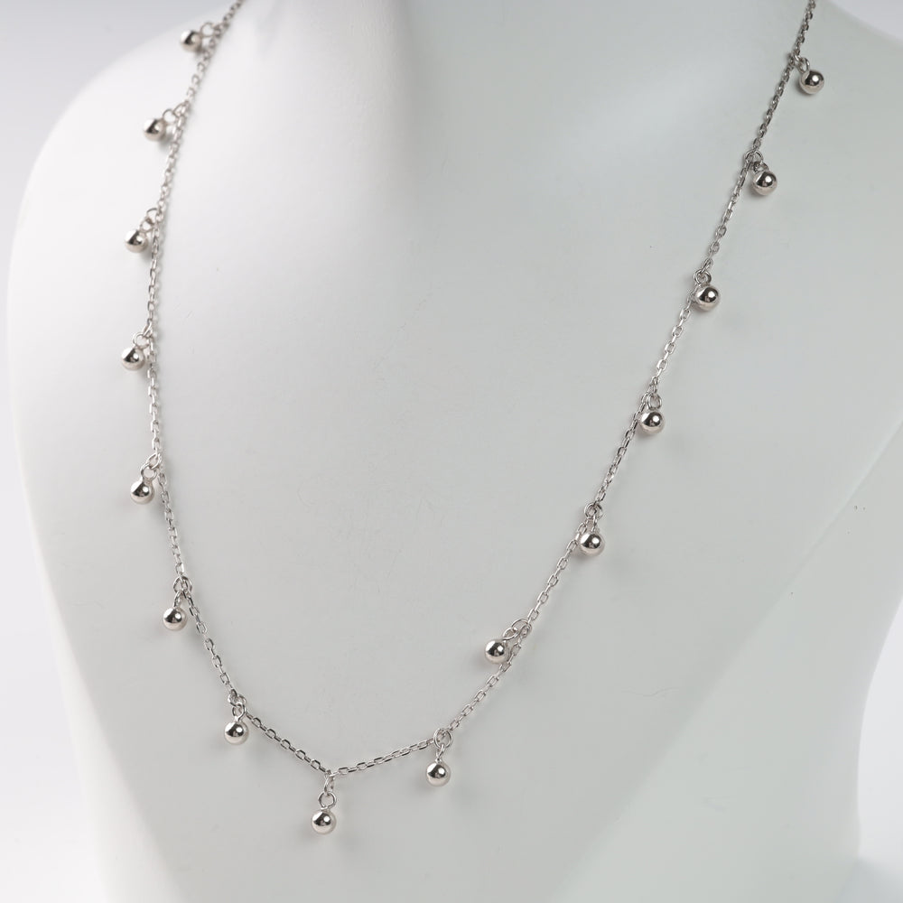Silver chain necklace with small round beads, displayed on a white bust.