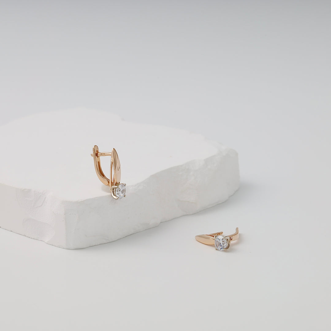 14k gold huggie earrings with round clear stones on white display, Ukrainian Jewelry, minimalist gold earrings for women.