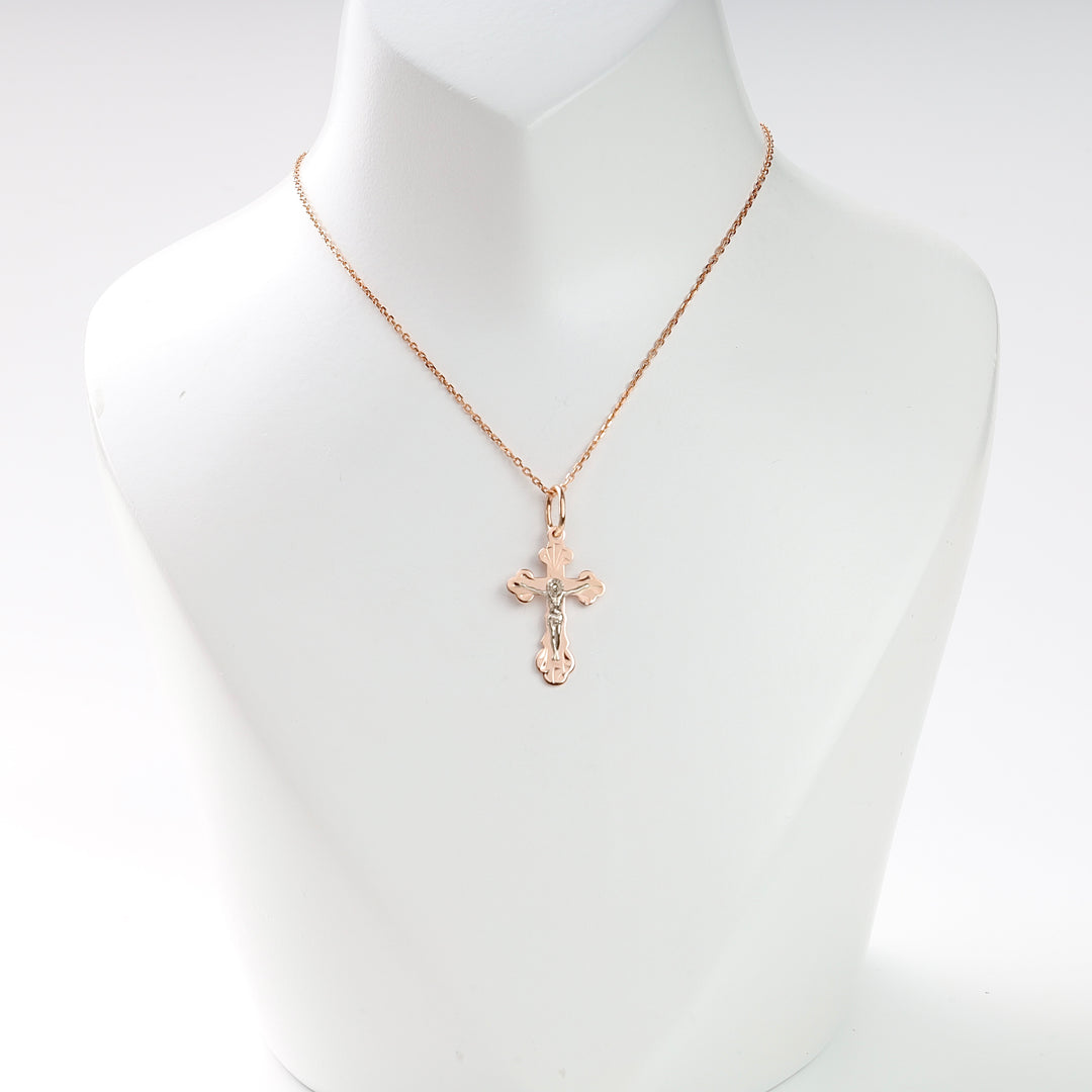 Gold chain necklace with a two-tone crucifix pendant displayed on a white jewelry bust for religious jewelry searches.