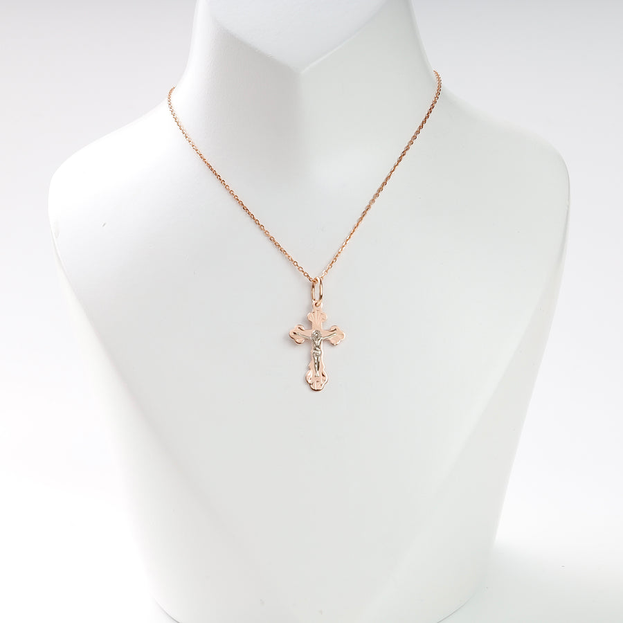 Gold chain necklace with a two-tone crucifix pendant displayed on a white jewelry bust for religious jewelry searches.