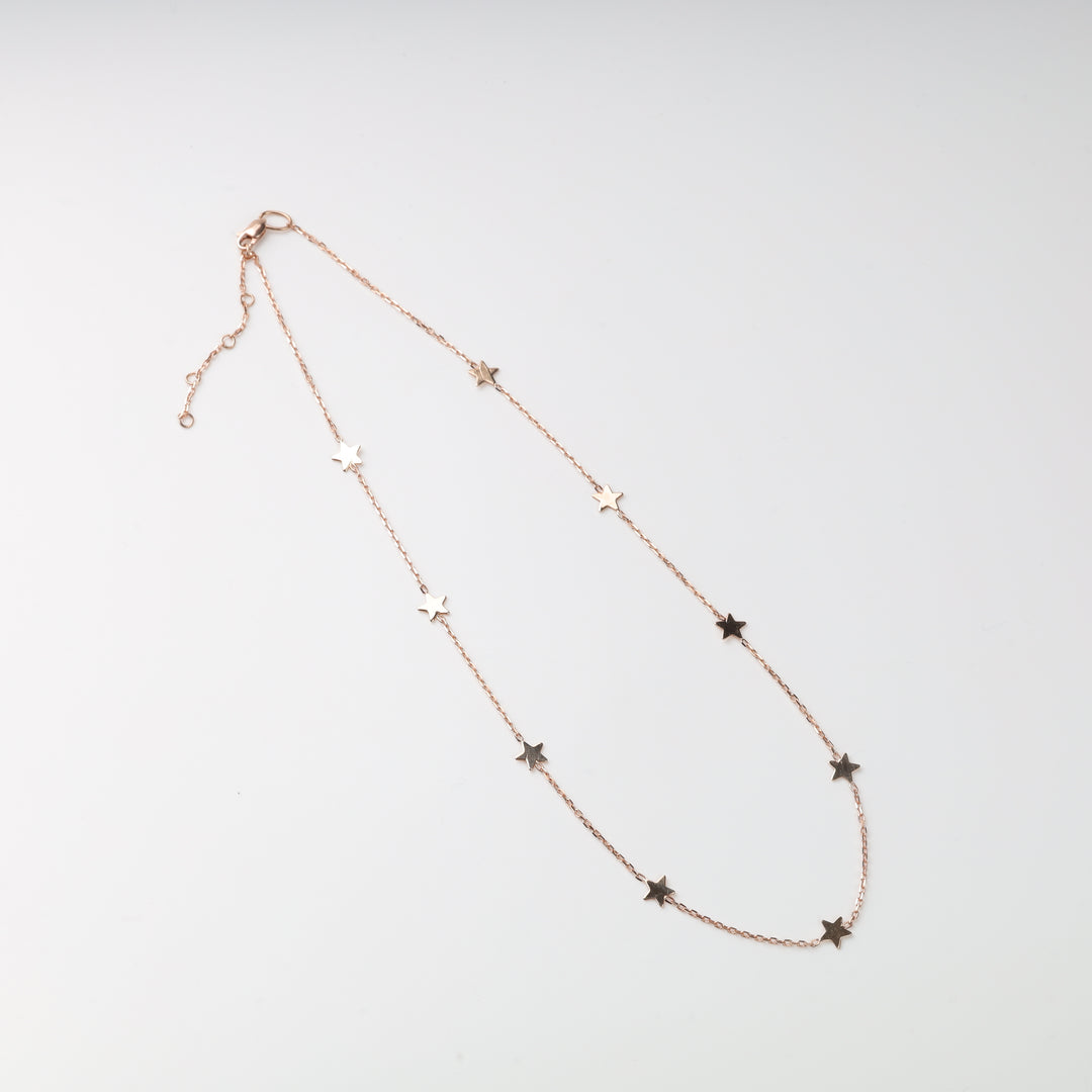 Rose gold star necklace with small stars on a delicate chain.