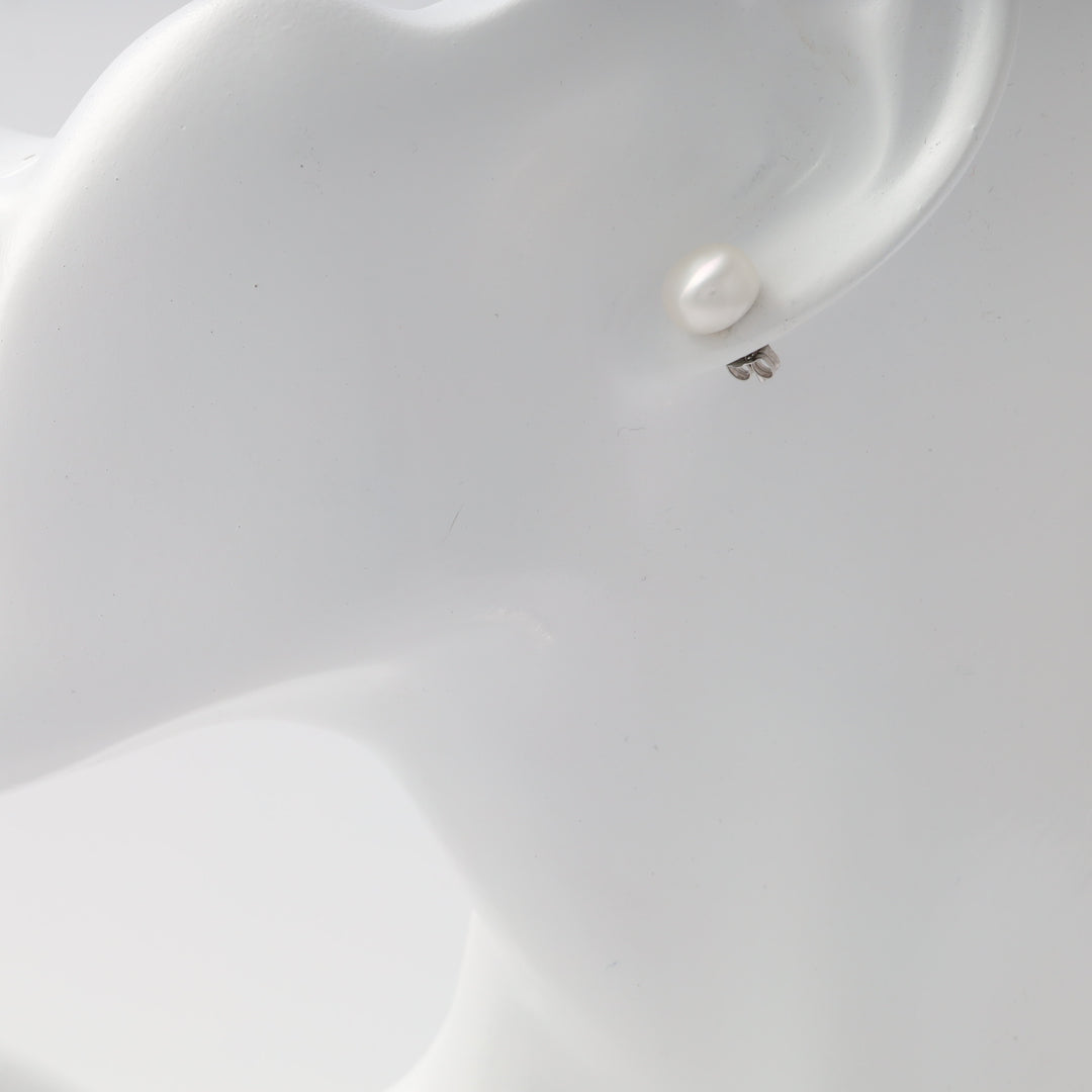 Single sterling silver and pearl stud earring on ear display, simple Ukrainian Jewelry pearl stud for minimalist silver earring shoppers.