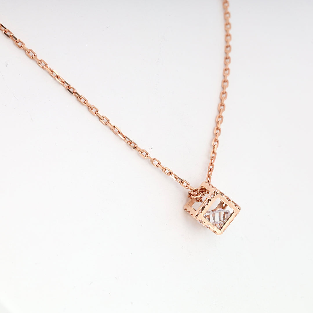 Rose gold chain necklace with a square open pendant holding a clear gemstone, displayed on a white background.
