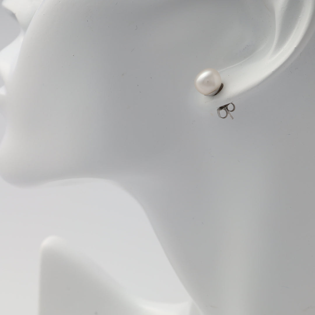 Single sterling silver stud earring with white pearl on display stand, classic pearl stud Ukrainian Jewelry for women.