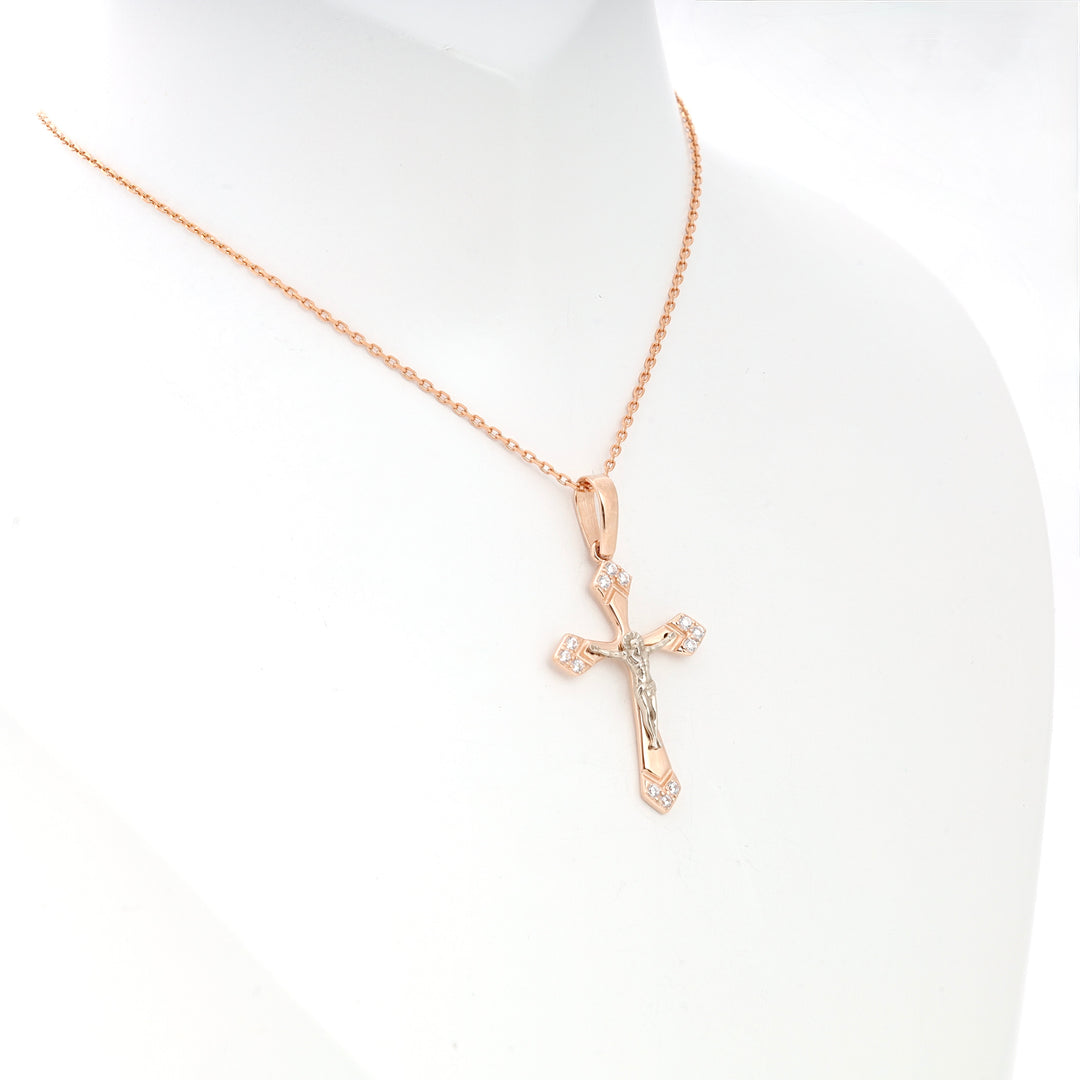 Rose gold crucifix necklace with small clear stones, displayed on a white bust, religious jewelry pendant.