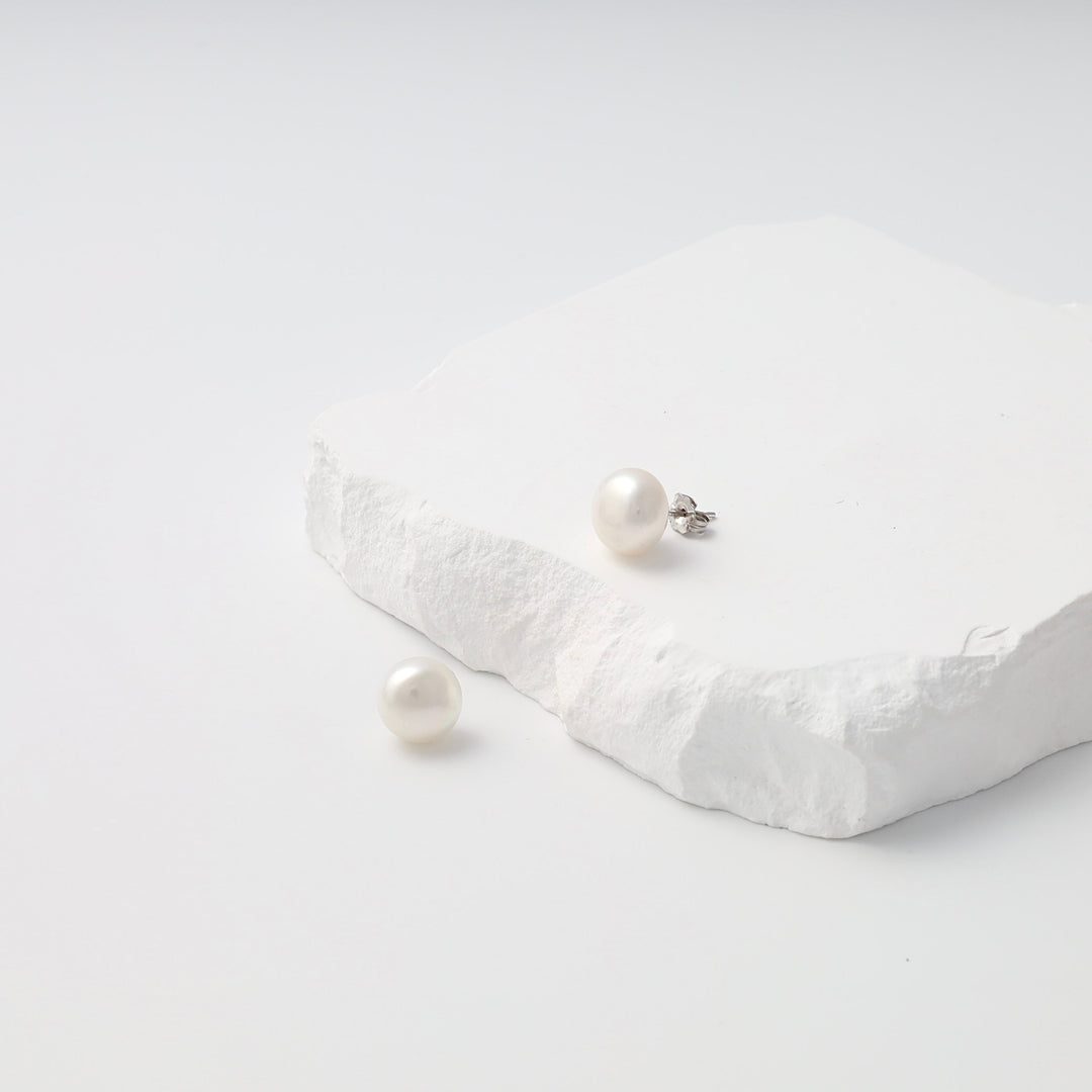 Single sterling silver pearl stud earring with loose matching pearl on white stone display, Ukrainian Jewelry, pearl stud earrings.