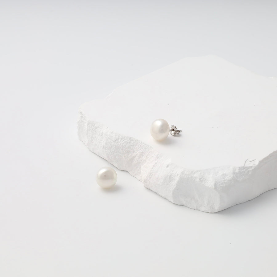 Single sterling silver pearl stud earring with loose matching pearl on white stone display, Ukrainian Jewelry, pearl stud earrings.