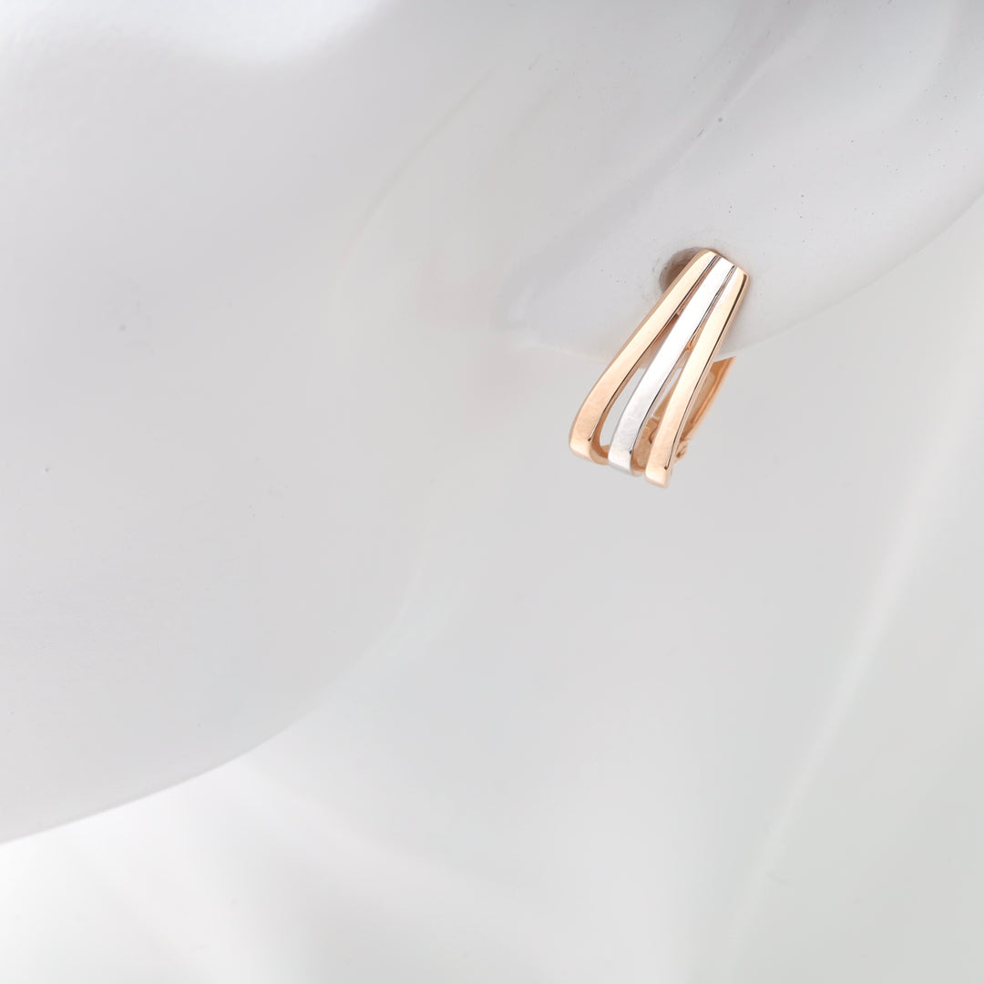 Gold and silver metal fan earrings shown on a mannequin.