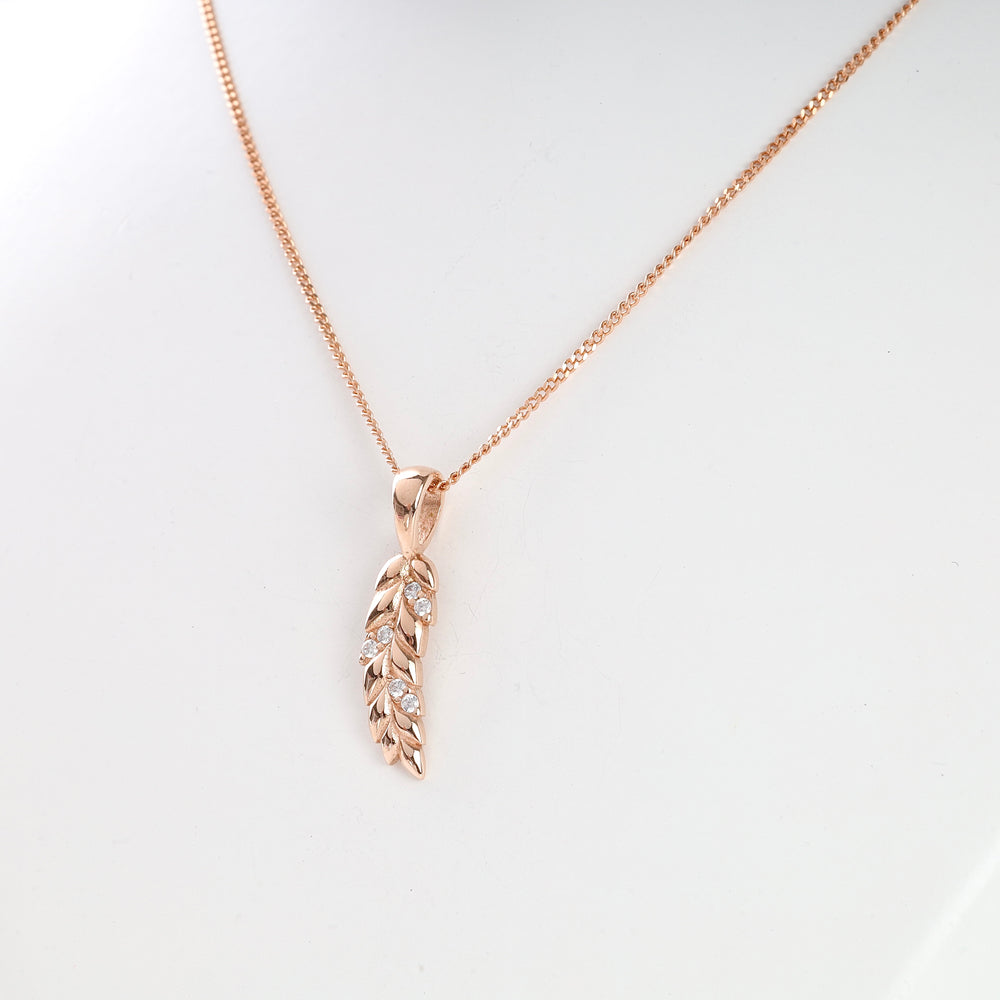 Rose gold chain necklace with a leaf-shaped pendant featuring small clear crystals, displayed on a white background.