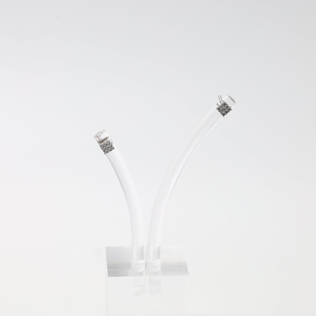 Sterling silver pavé tube end caps on white cord, displayed upright on clear stand, minimalist Ukrainian Jewelry necklace findings.