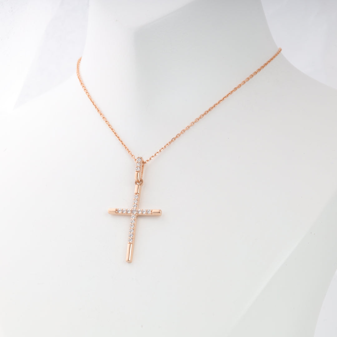 Rose gold cross pendant necklace with clear crystals shown on a white display bust, religious jewelry, minimalist cross necklace.