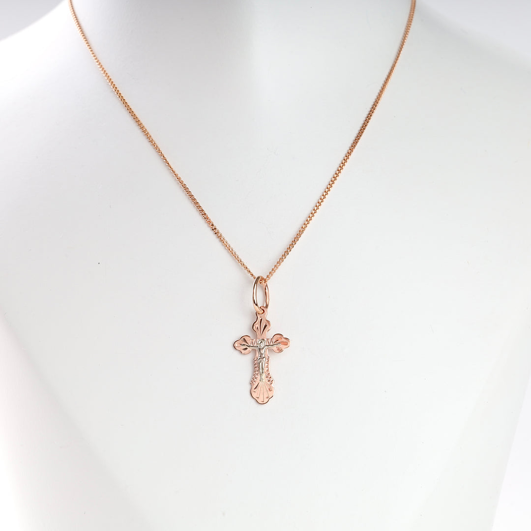 Rose gold cross necklace with engraved detailing displayed on a white bust, Christian jewelry, cross pendant, faith necklace.
