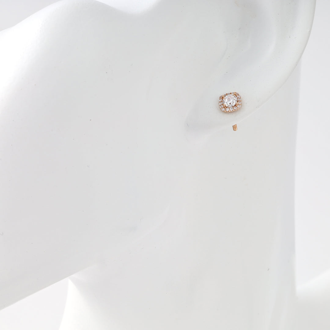 Single 14k gold stud earring with cushion halo and round clear stone on ear model, Ukrainian Jewelry, delicate gold stud earring.