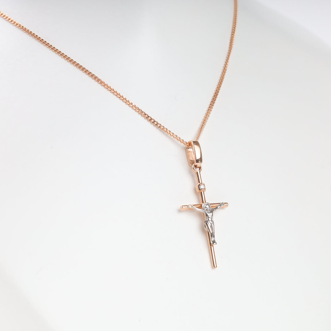Rose gold chain necklace with a two-tone crucifix pendant featuring Jesus, displayed on a white mannequin.