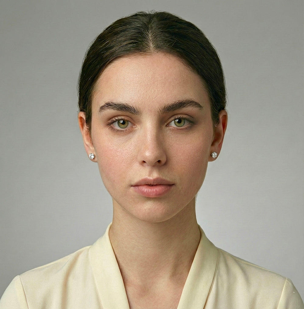 Woman wearing a light-colored top against a neutral background with white gold diamond earrings 1 Ct