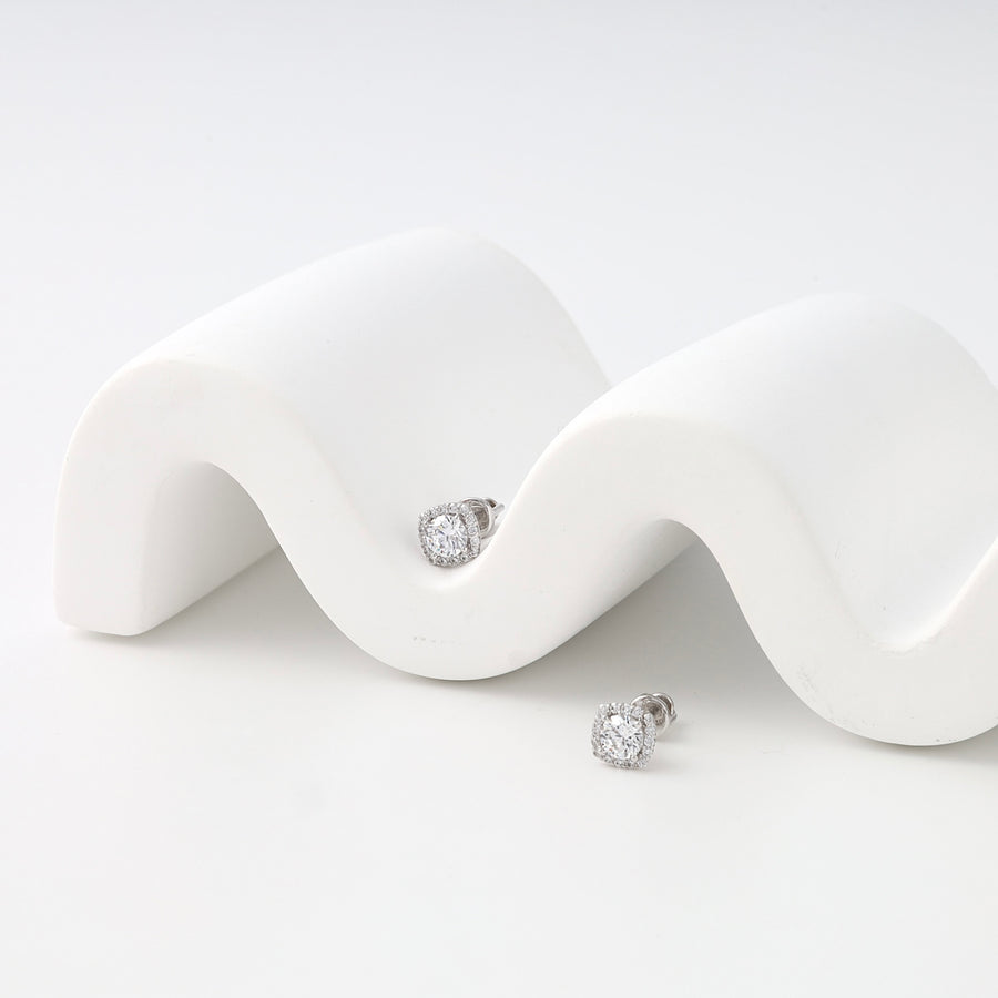 Earrings screw-back on a white wavy surface