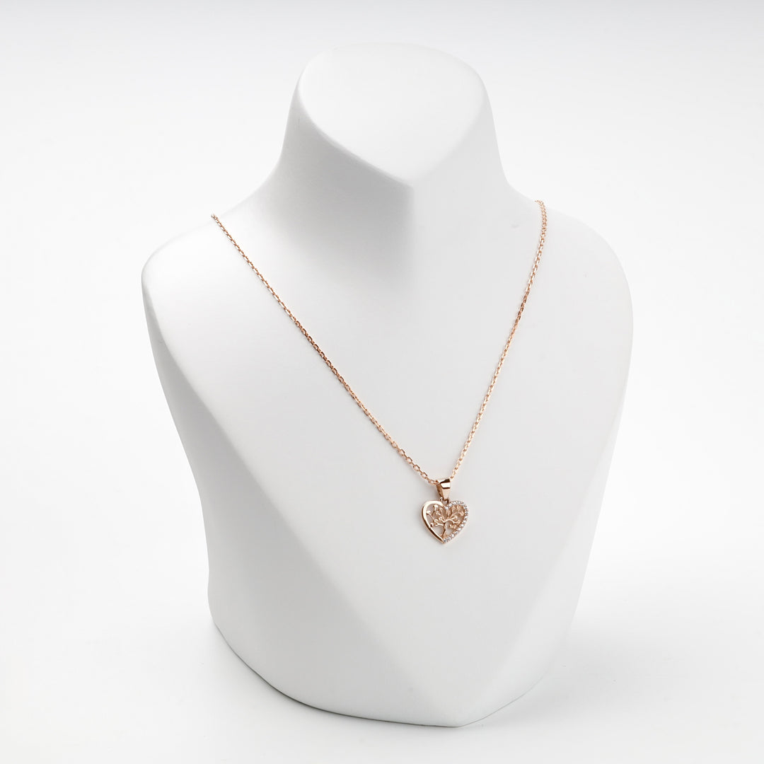 Rose gold heart tree of life pendant on display