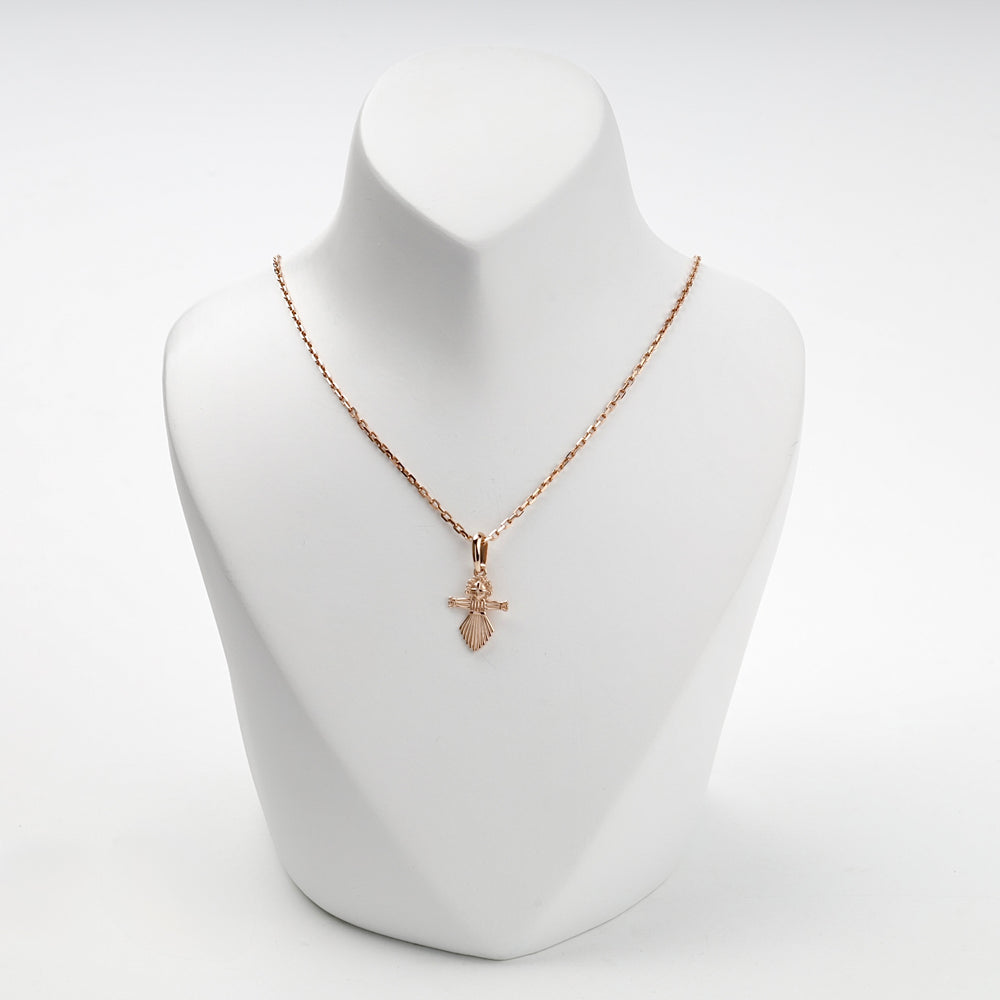 Rose gold folk-doll pendant with pleated skirt, studio view