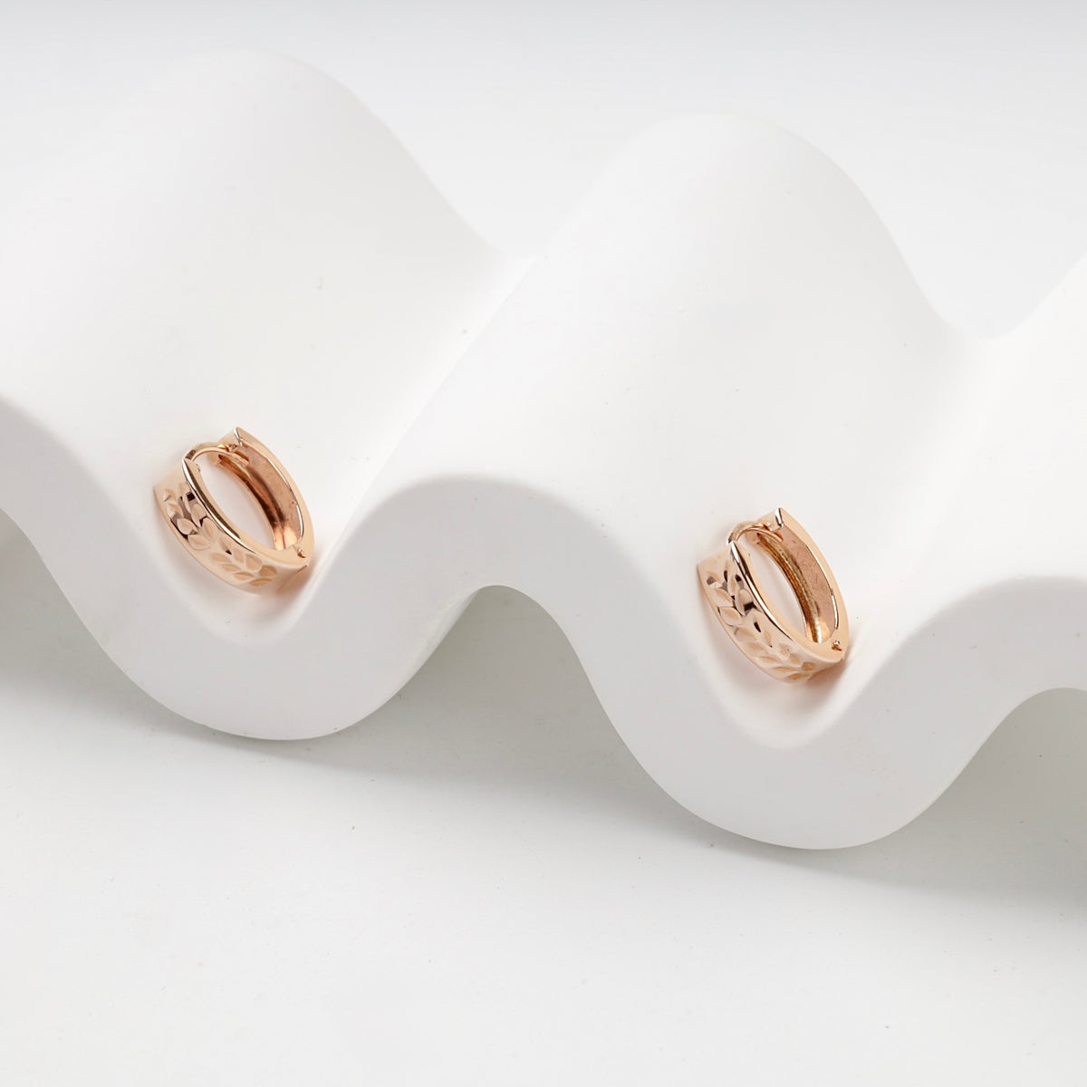 Patterned Huggie Hoop Earrings | 14K Rose Gold (585) — angled view