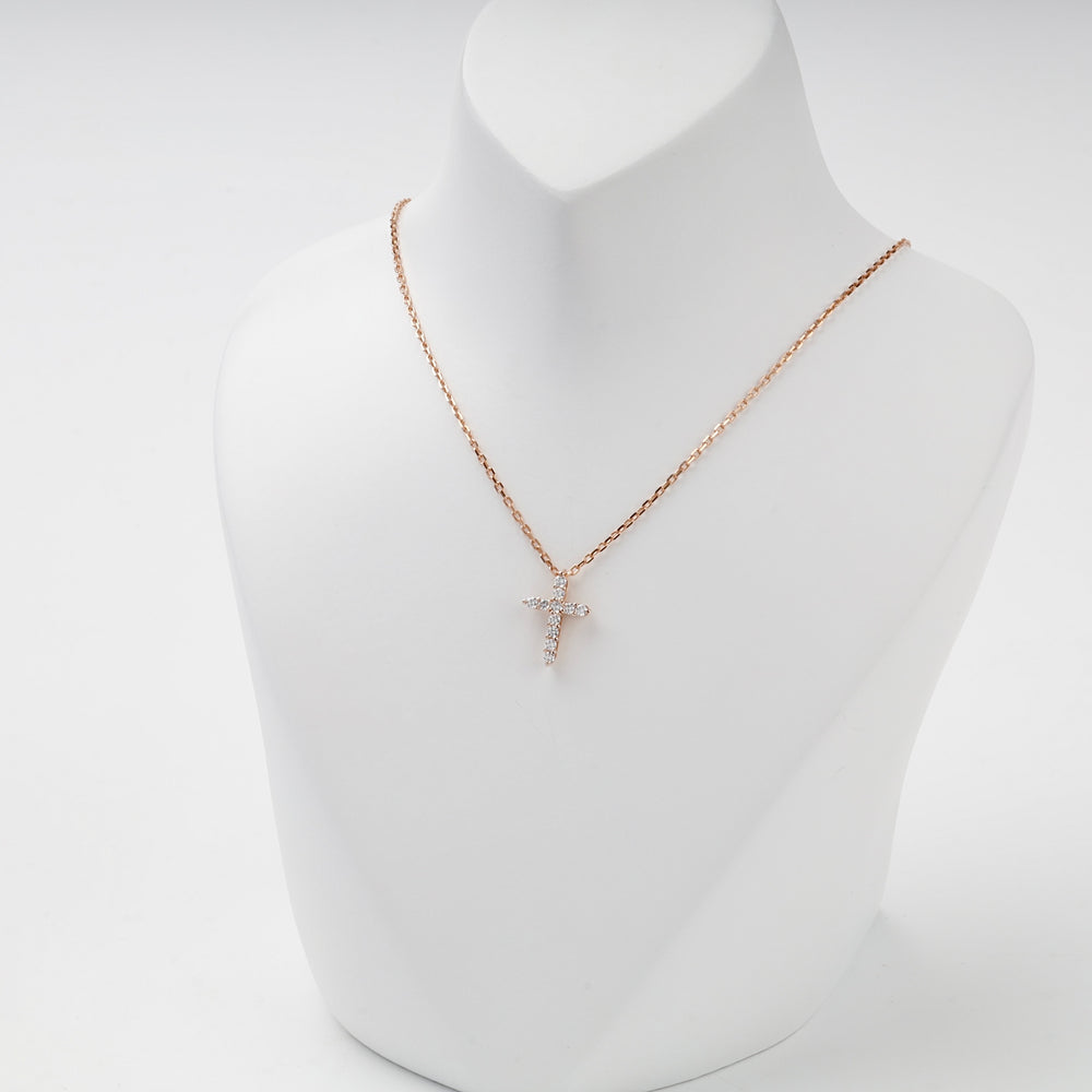 Small rose gold cross pendant with cubic zirconia, studio view