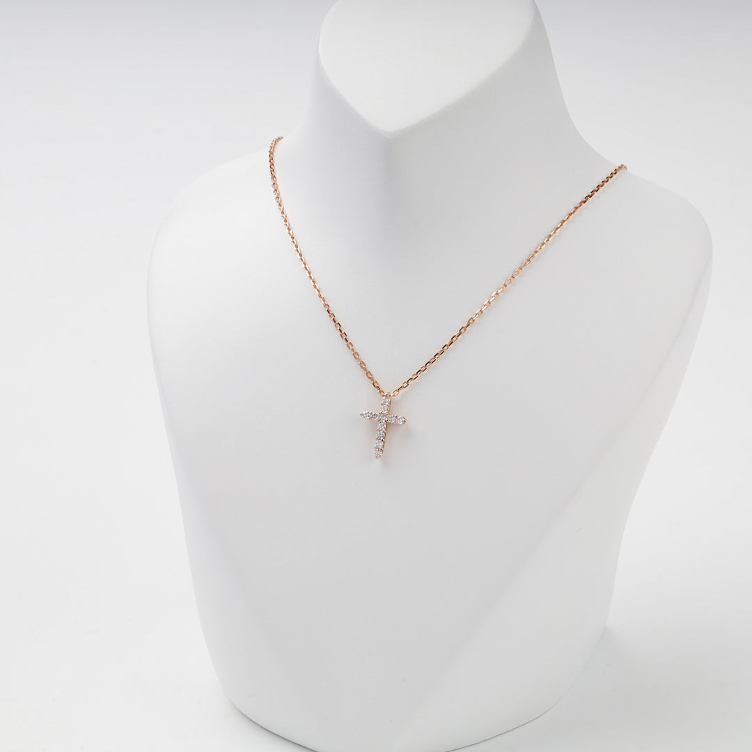 Small rose gold cross pendant with cubic zirconia, studio view