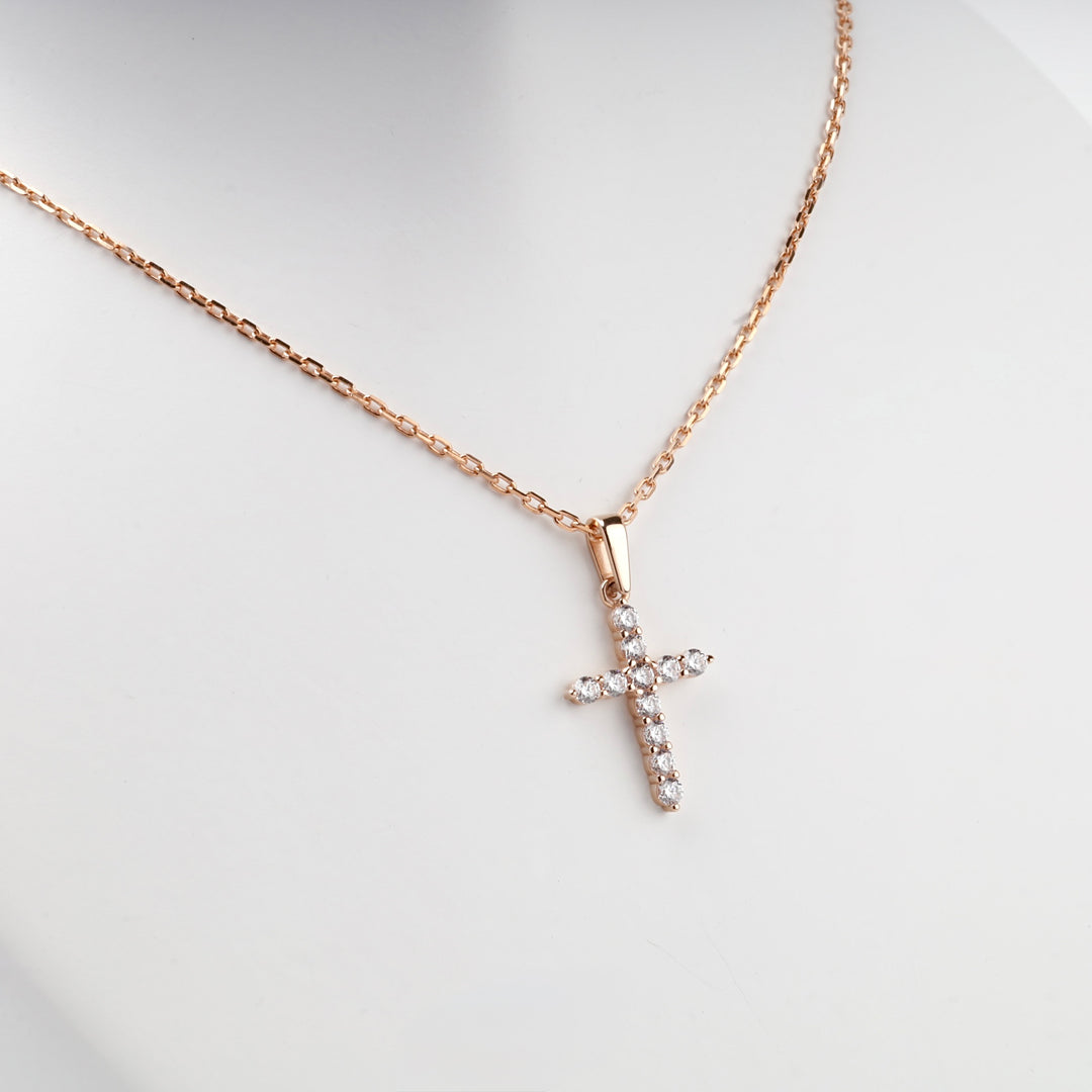 Rose gold cross pendant with cubic zirconia on a chain, front view