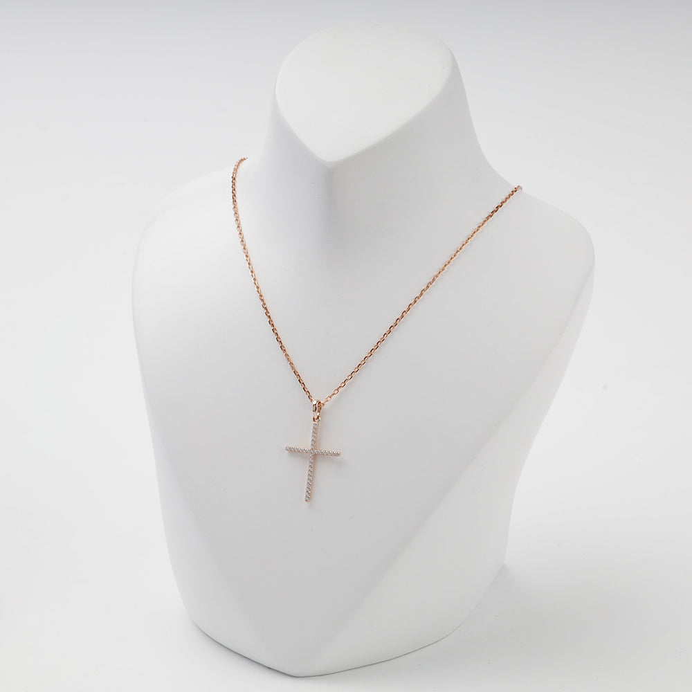 Slim rose gold cubic zirconia cross pendant, angled view