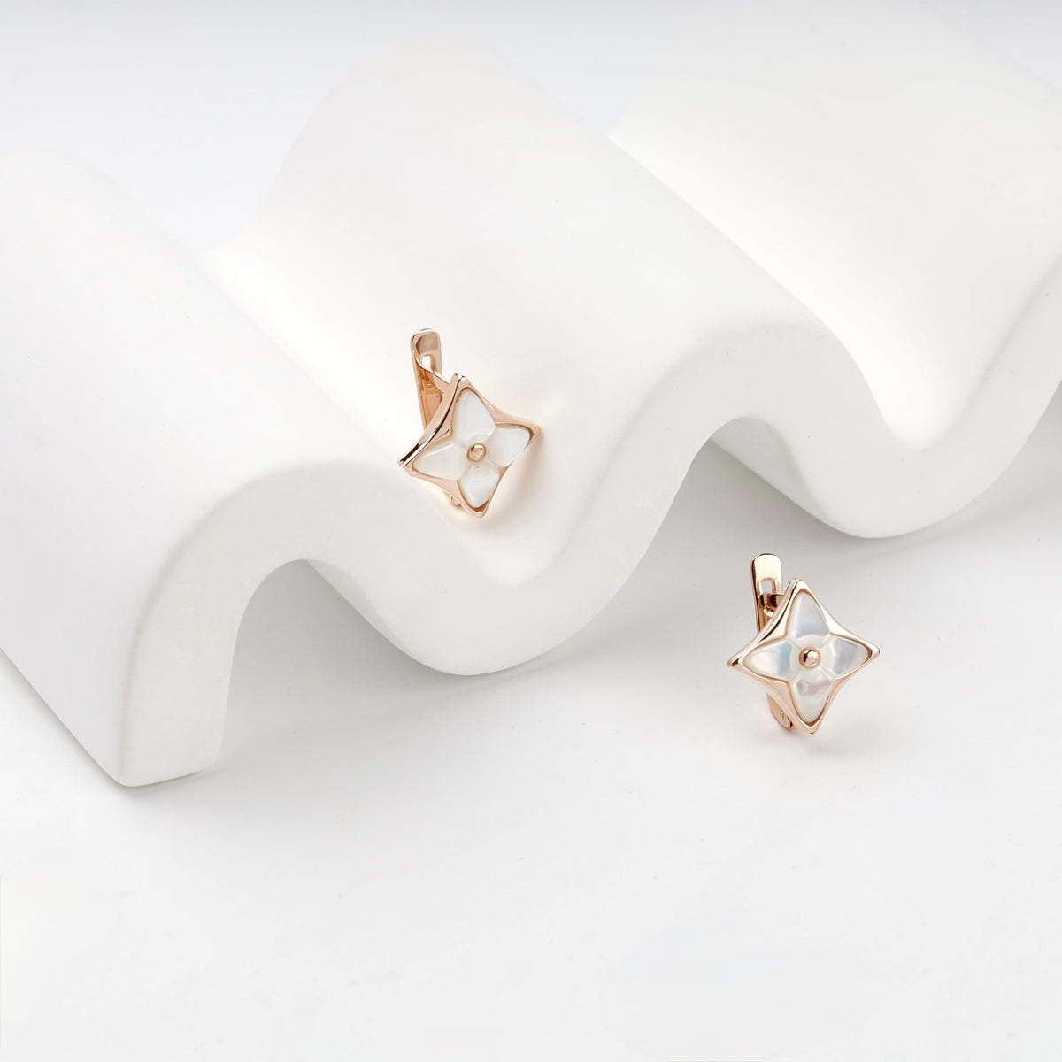 Rose gold star earrings with mother of pearl front view