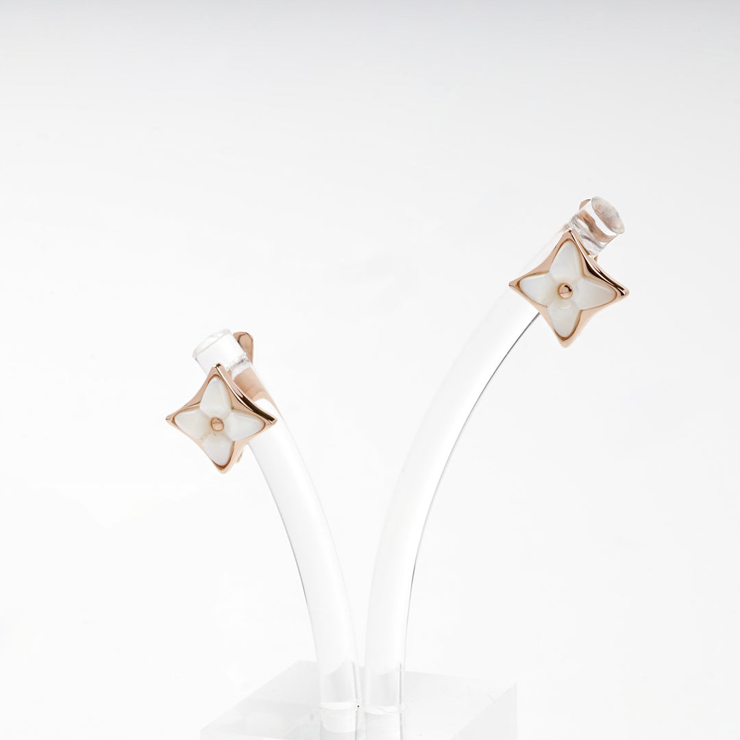 Rose gold star earrings on white background