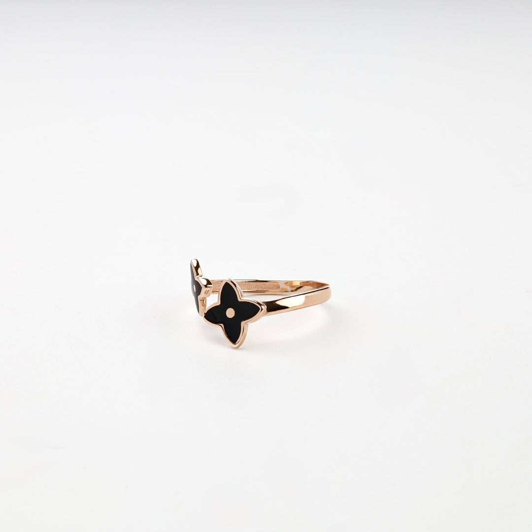 Rose gold ring black flower on white surface