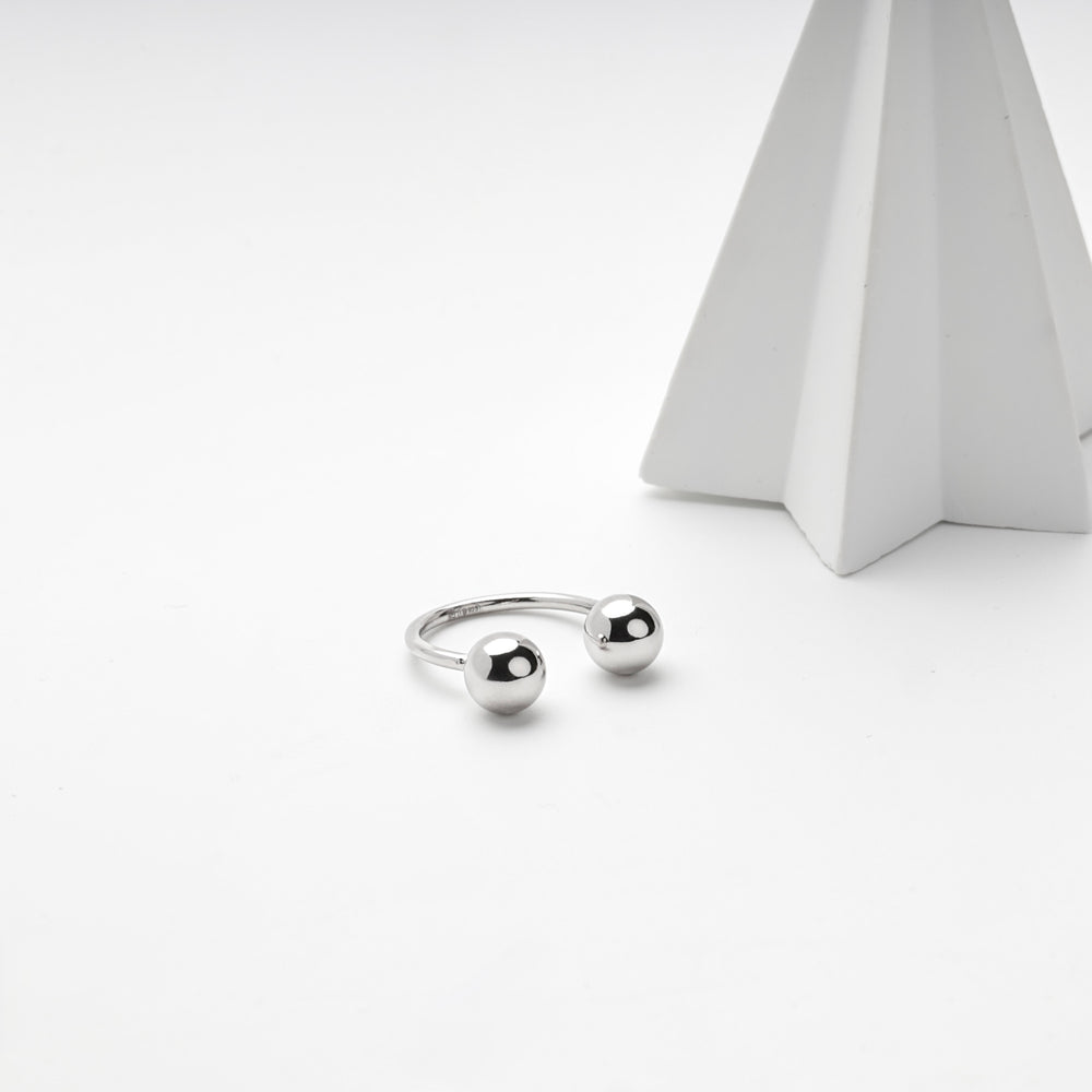 Silver 925 open ball ring beside a white pyramid prop