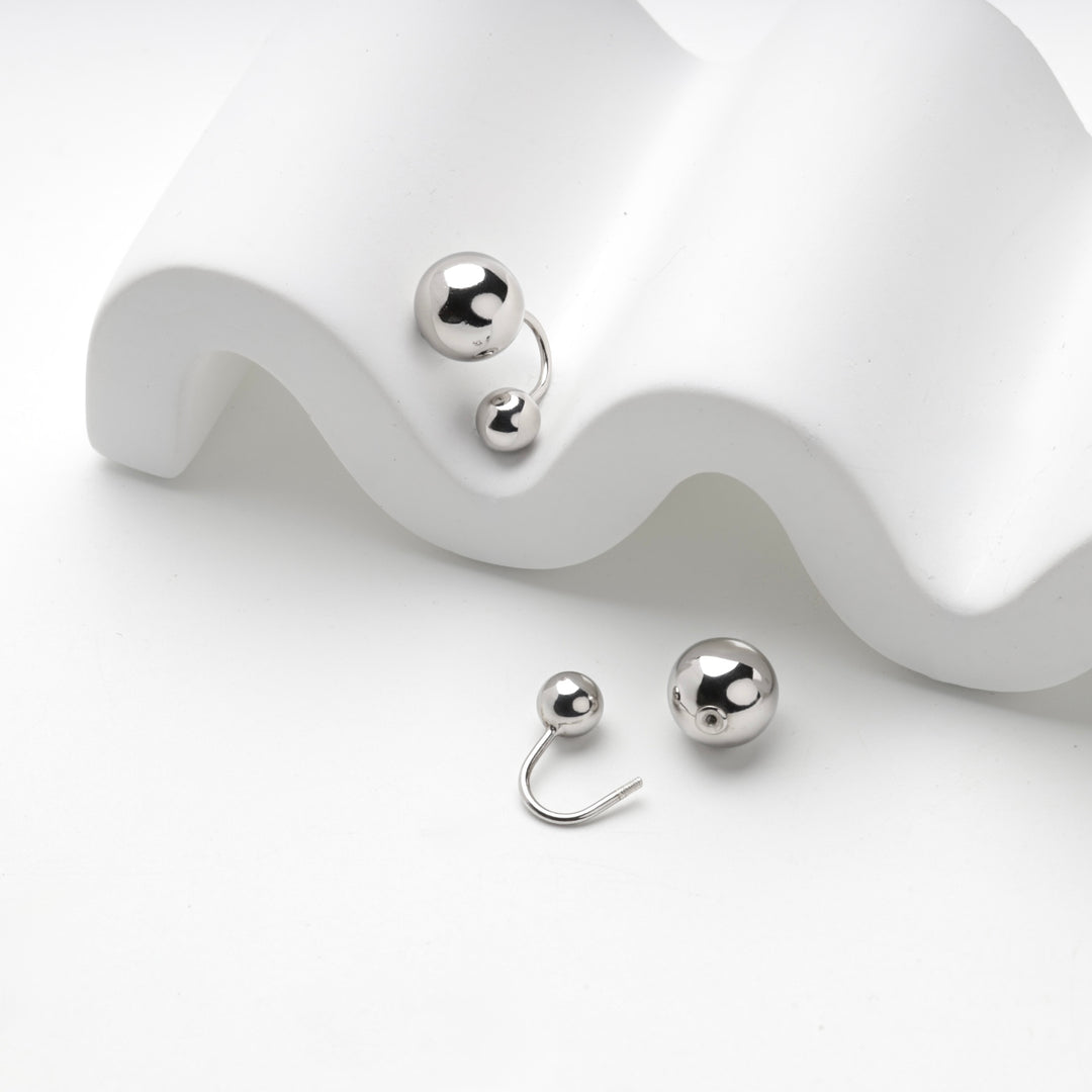 Close view of the two polished silver balls on the curved post