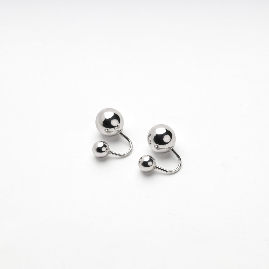 Pair of silver 925 ball duo earrings laid flat on a white background