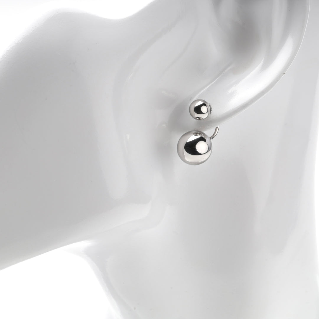 Small ball at the piercing and larger ball below the lobe on a mannequin ear