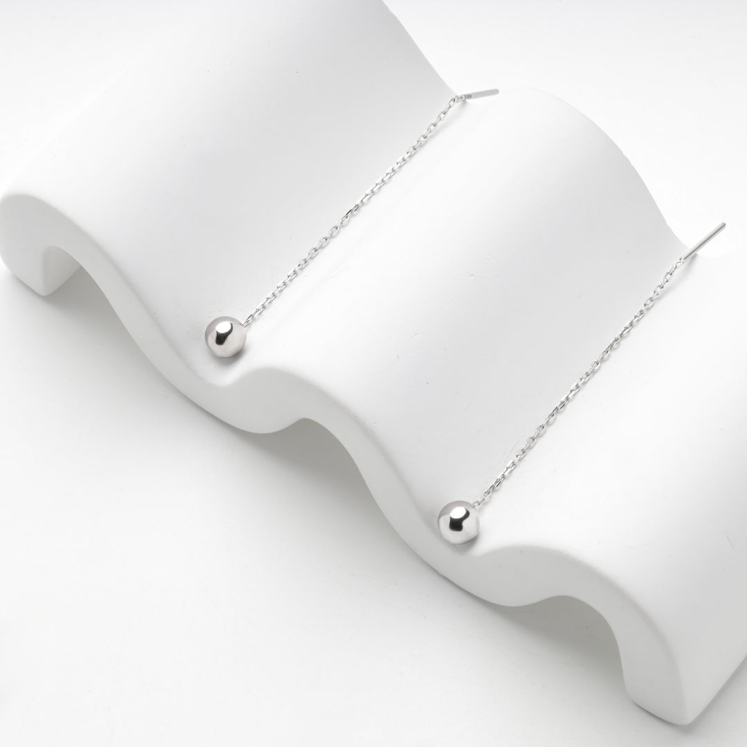 Silver 925 threader earrings with polished balls, angled view on a wave stand