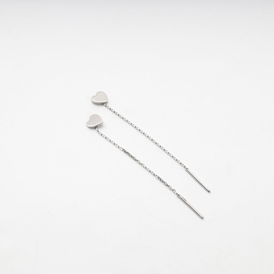 Silver 925 heart threader earrings laid straight on a white background