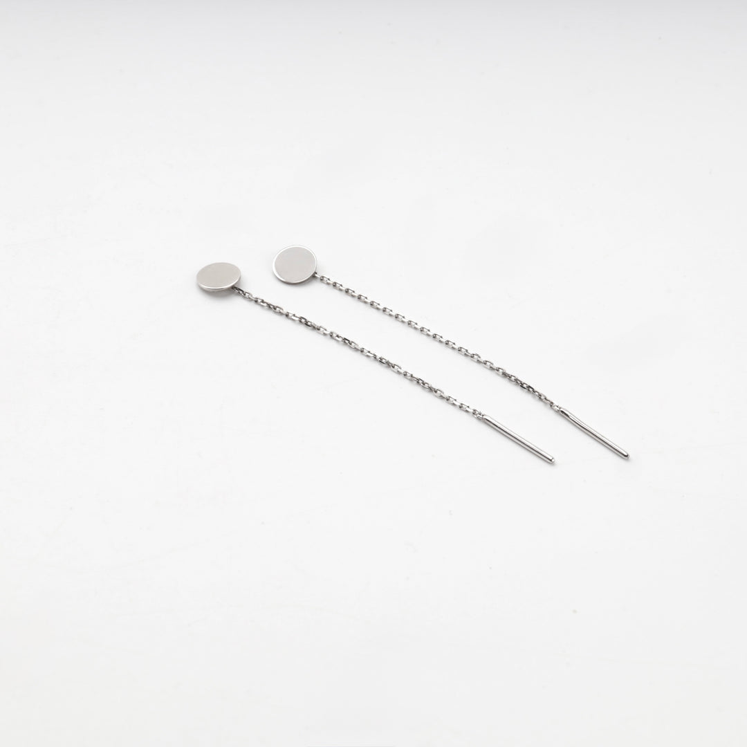Pair of silver 925 disc threader earrings laid flat