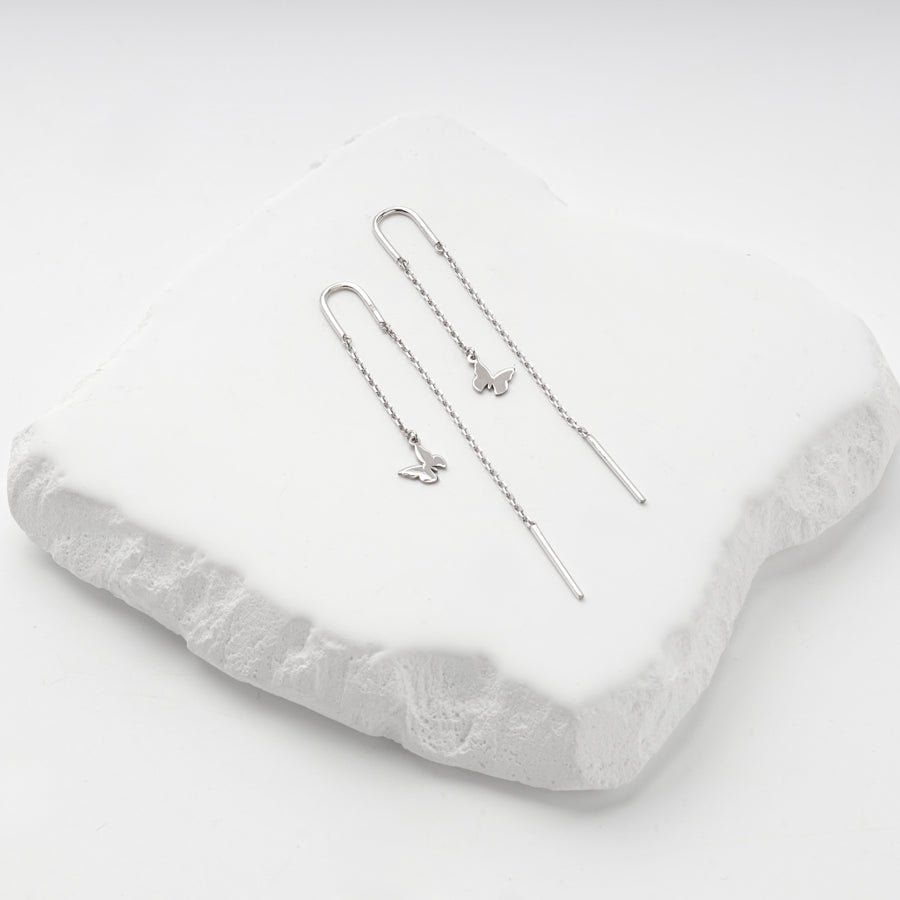Silver 925 butterfly threader earrings on a white stone slab