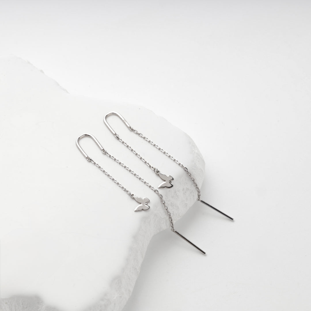 Silver 925 threader earrings with butterfly charms, angled view