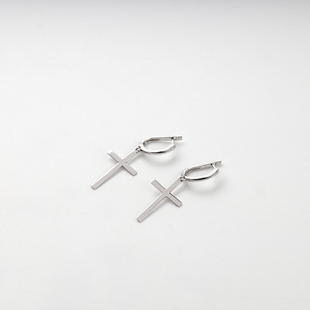 Pair of silver 925 cross drop earrings lying flat on a white background