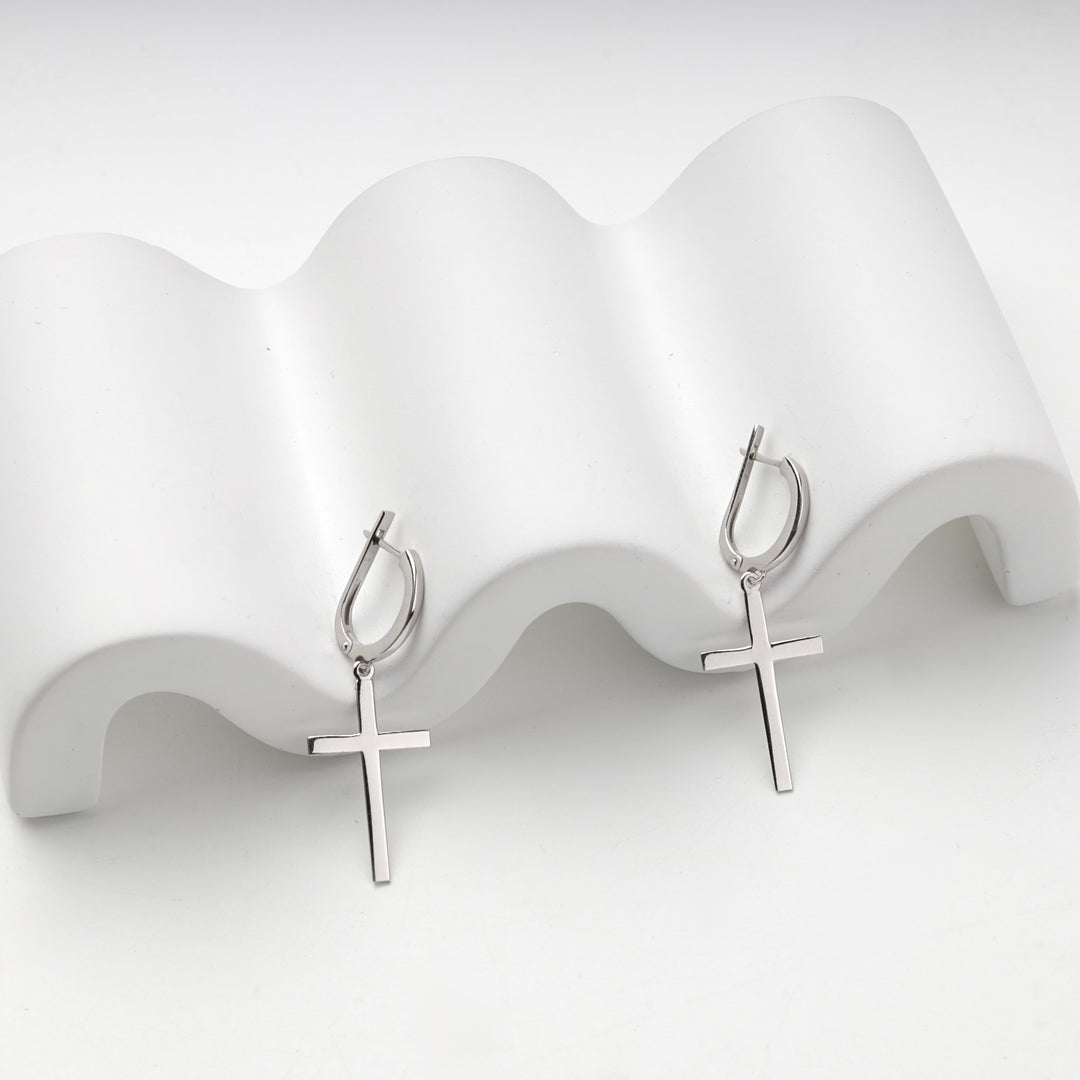 Silver 925 cross drop earrings on a wave stand, side angle