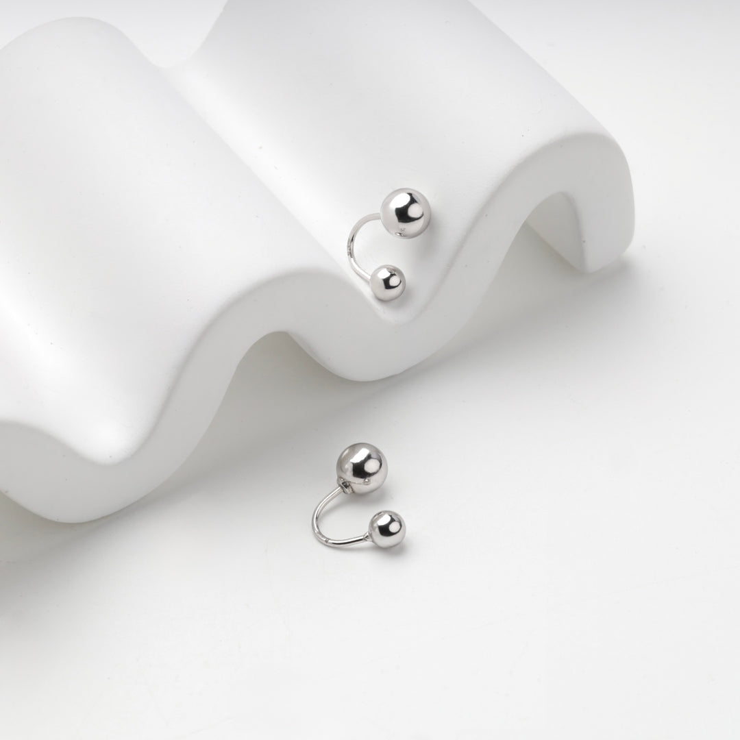 Silver 925 double ball earrings on a white wave stand