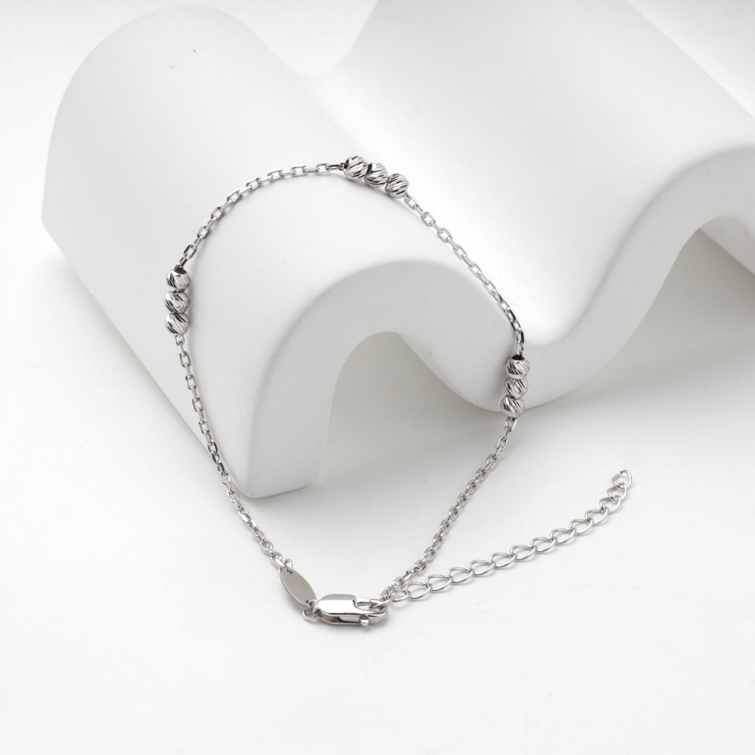 Silver 925 diamond-cut bead bracelet arranged on a white display block
