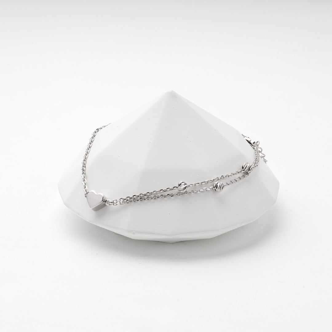 Silver 925 heart bracelet resting on a white faceted prop
