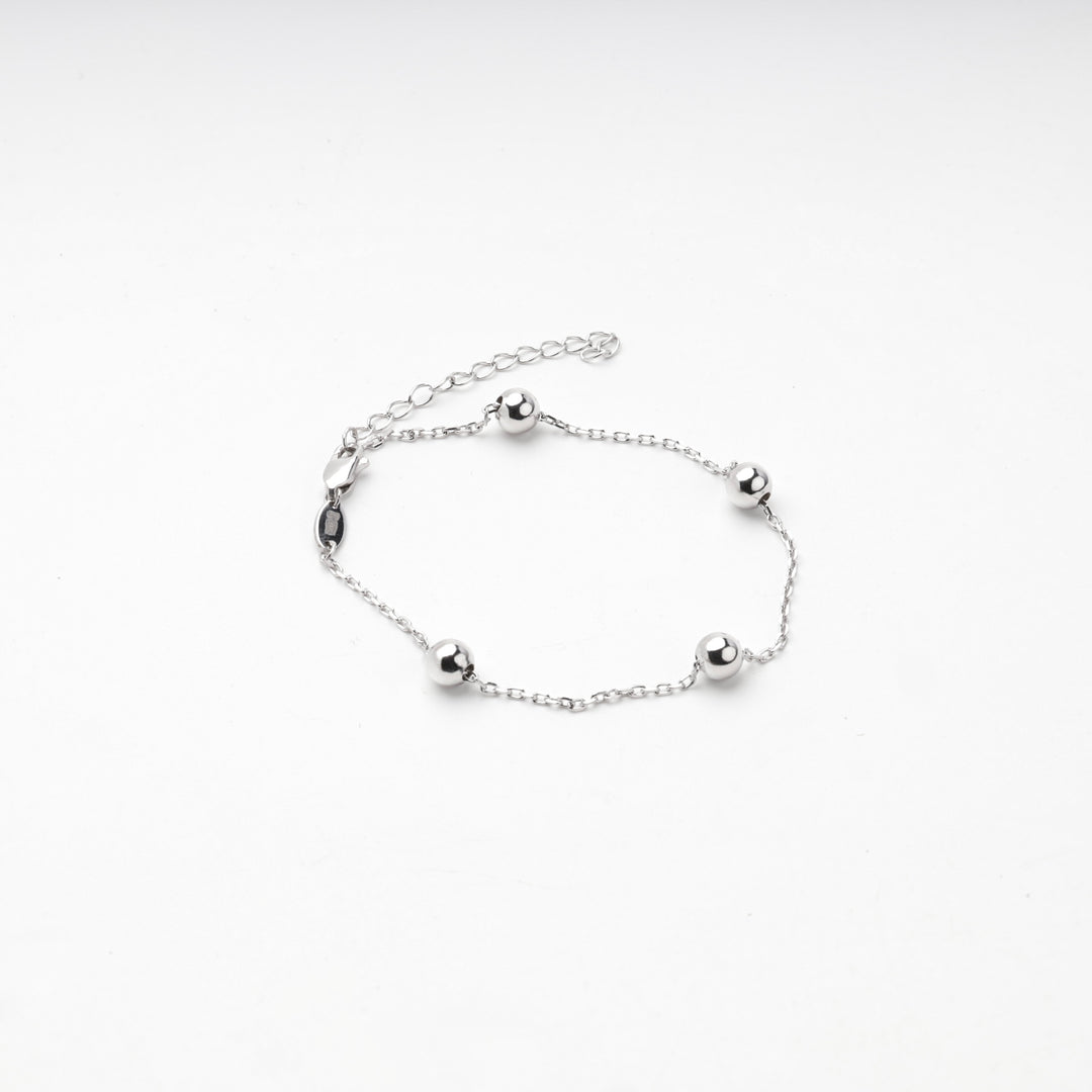 Silver 925 ball station bracelet laid flat with clasp and extender chain